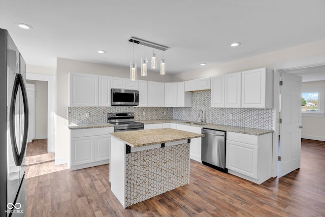 kitchen with hardwood / wood-style flooring, white cabinets, and appliances with stainless steel finishes