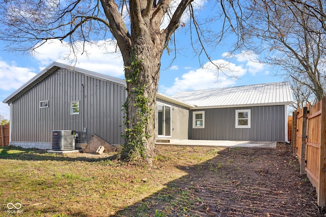 back of property with a patio, central AC, and a lawn