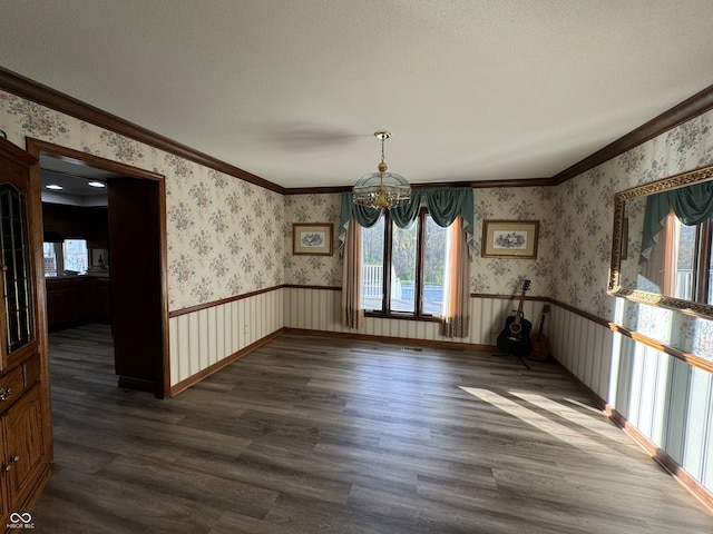 unfurnished dining area with a chandelier, a textured ceiling, dark hardwood / wood-style floors, and crown molding