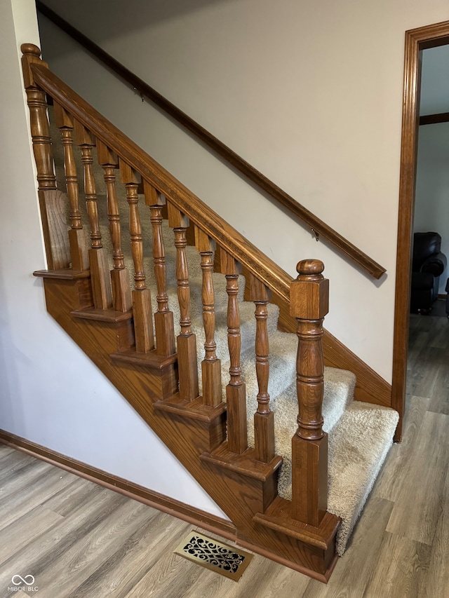 staircase with hardwood / wood-style flooring