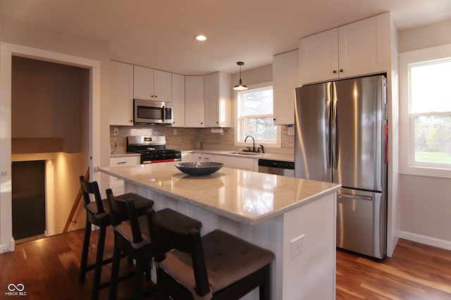 kitchen featuring white cabinets, decorative light fixtures, sink, and stainless steel appliances