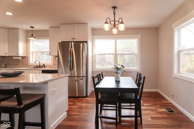 kitchen with white cabinetry, stainless steel fridge, plenty of natural light, and pendant lighting