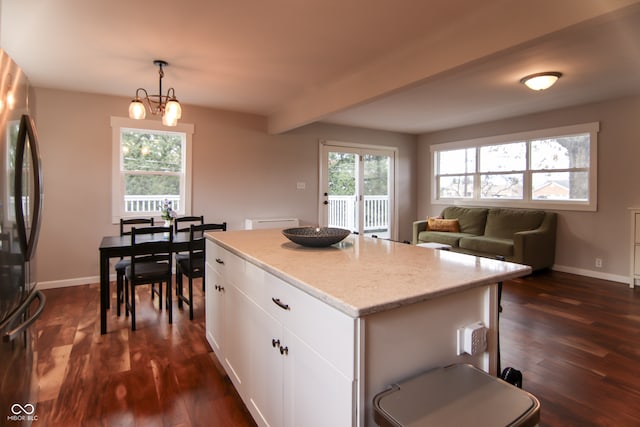 kitchen with white cabinetry, a center island, dark hardwood / wood-style floors, fridge, and decorative light fixtures