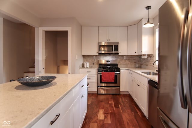 kitchen featuring sink, stainless steel appliances, dark hardwood / wood-style flooring, pendant lighting, and white cabinets