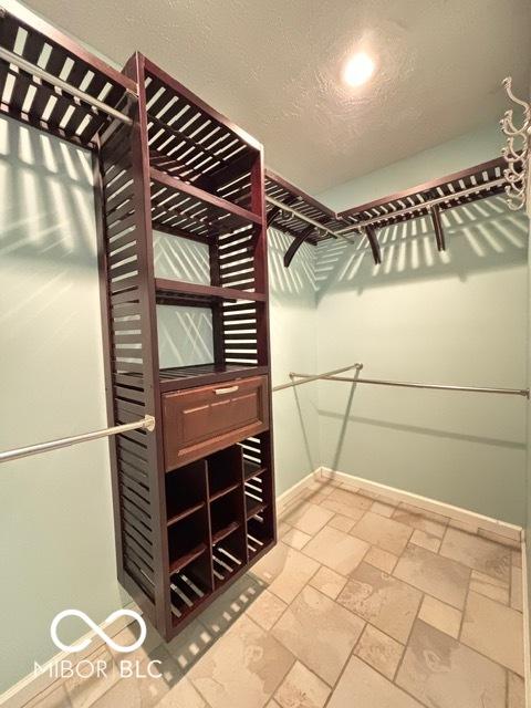 walk in closet featuring stone tile flooring