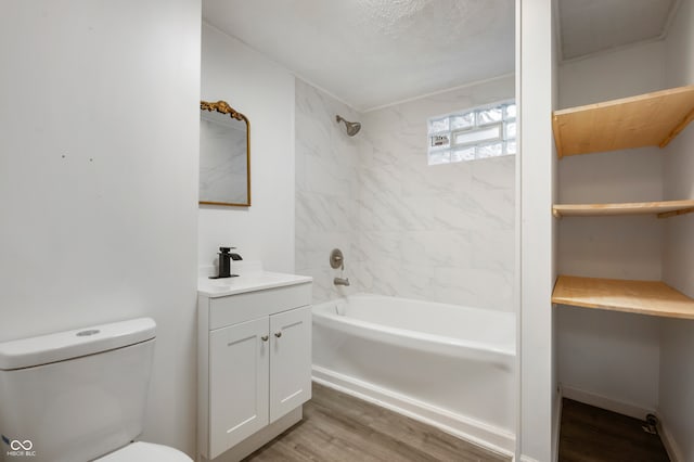 full bathroom with toilet, vanity, wood-type flooring, and tiled shower / bath