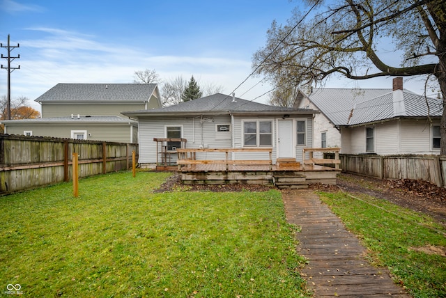 rear view of property featuring a deck and a lawn