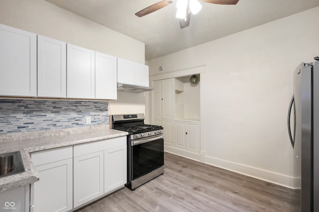 kitchen featuring decorative backsplash, white cabinets, light wood-type flooring, and appliances with stainless steel finishes