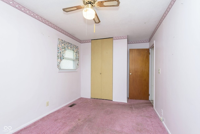 unfurnished bedroom featuring ceiling fan, light carpet, and a closet