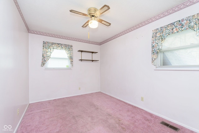 empty room featuring ceiling fan, crown molding, and light colored carpet