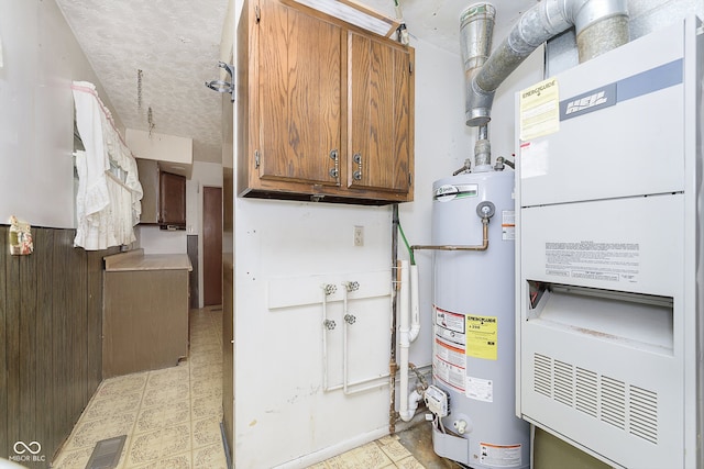 utility room featuring heating unit and water heater