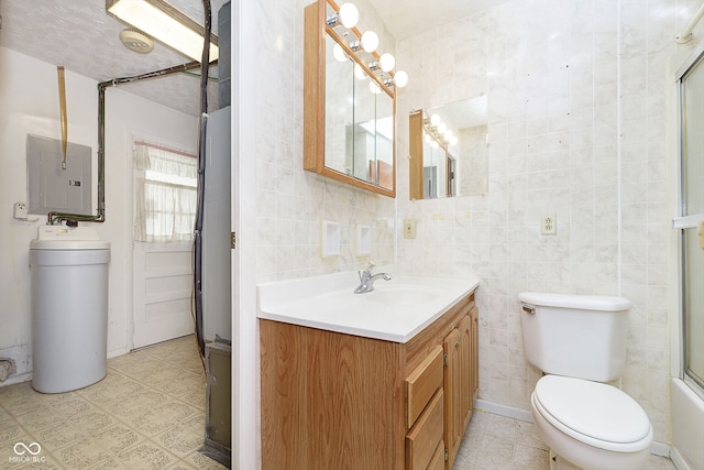 full bathroom featuring vanity, electric panel, toilet, and tile walls