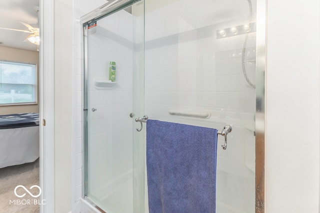 bathroom with a shower with door and ceiling fan