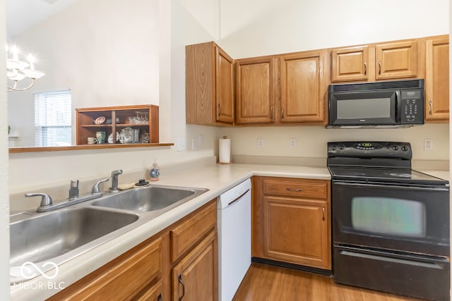 kitchen with black appliances, light wood-type flooring, and sink