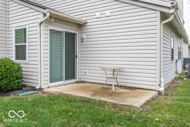 doorway to property featuring a patio area, a yard, and central AC unit