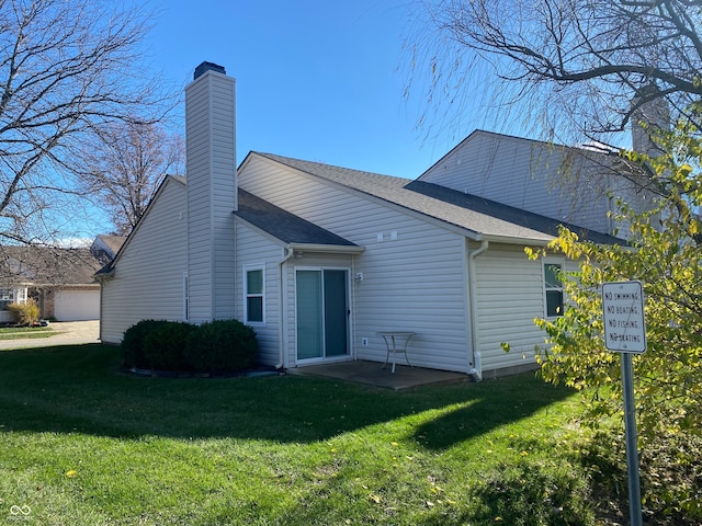 rear view of house with a patio area and a lawn