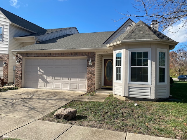 view of front of property with a garage and a front lawn