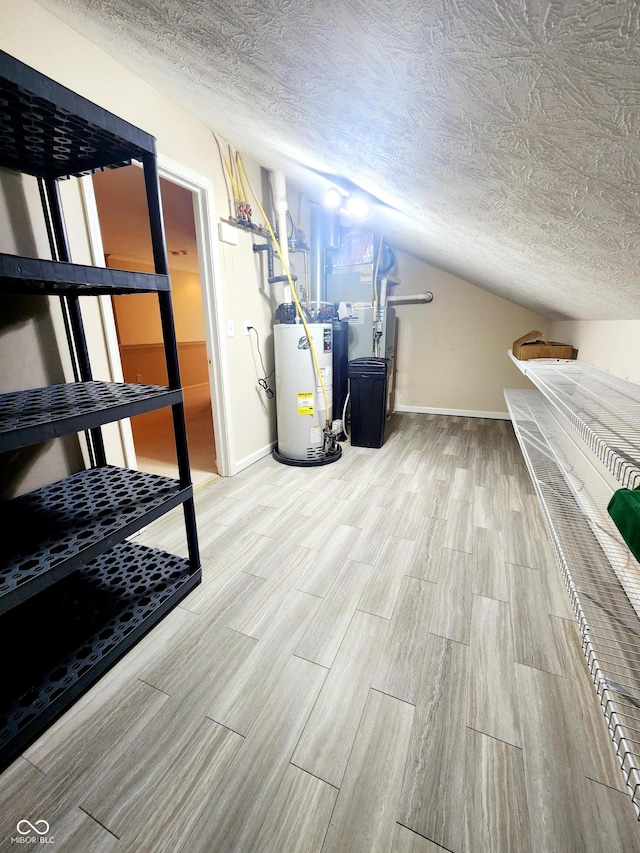 basement featuring gas water heater and a textured ceiling