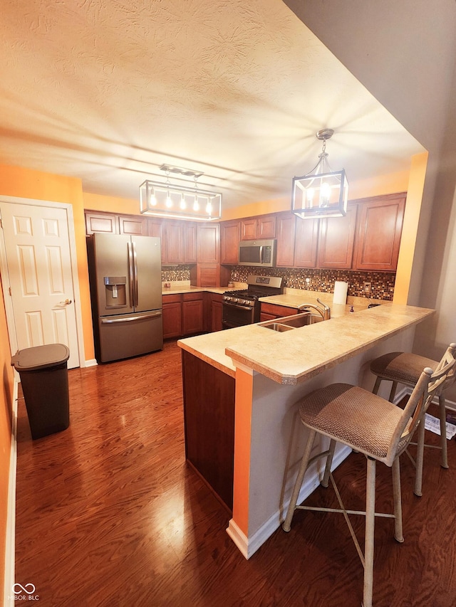 4835 Franklin Villas Dr, Indianapolis, IN 46237 - kitchen featuring stainless steel appliances, a peninsula, light countertops, a breakfast bar, and a textured ceiling
