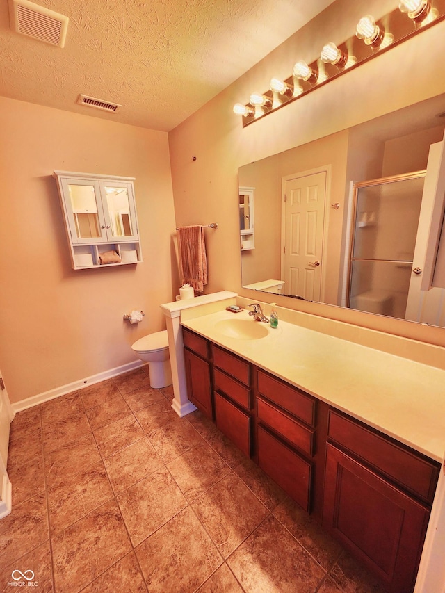 bathroom featuring walk in shower, vanity, toilet, and a textured ceiling