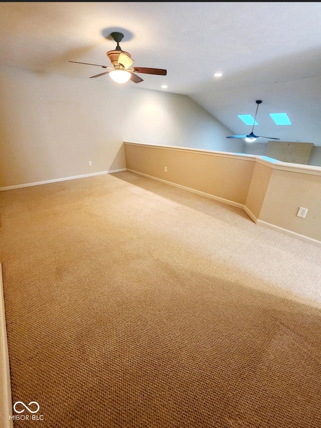 additional living space featuring ceiling fan, lofted ceiling with skylight, and carpet