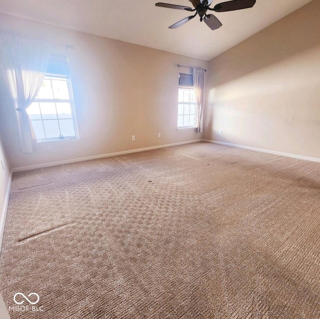 carpeted spare room featuring ceiling fan