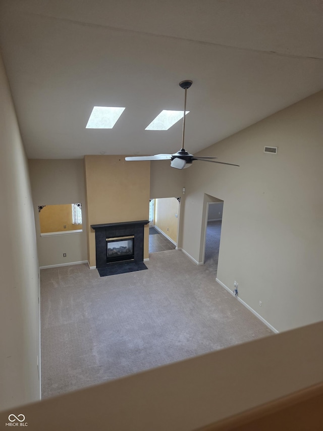 4835 Franklin Villas Dr, Indianapolis, IN 46237 - unfurnished living room with a skylight, carpet flooring, a tile fireplace, lofted ceiling, and ceiling fan