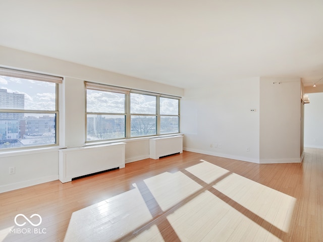 spare room with radiator and light wood-type flooring