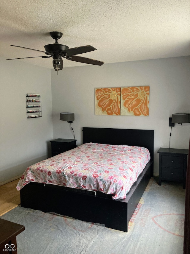 bedroom with ceiling fan and a textured ceiling