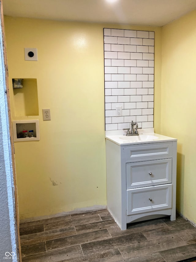 bathroom featuring decorative backsplash, hardwood / wood-style floors, and vanity