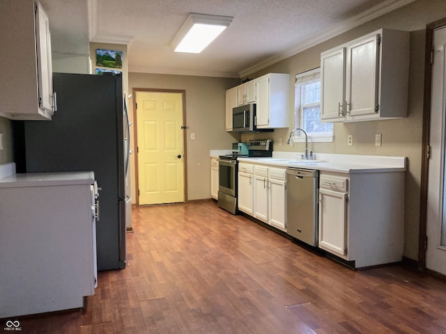 kitchen featuring white cabinetry, sink, stainless steel appliances, dark hardwood / wood-style flooring, and crown molding