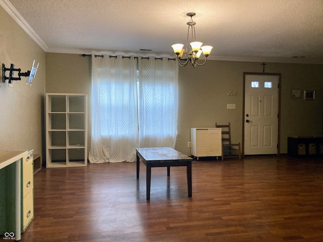 dining room featuring crown molding, dark hardwood / wood-style flooring, a chandelier, and a textured ceiling