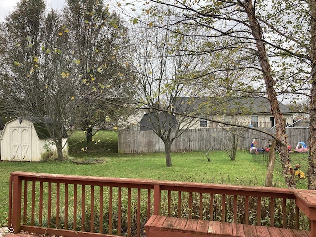 wooden deck with a shed and a lawn