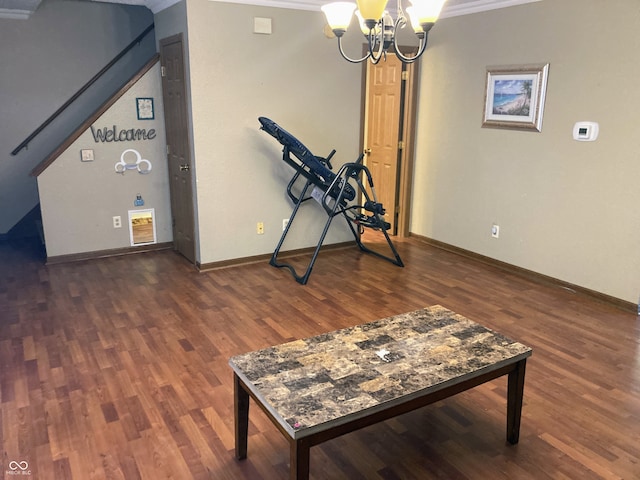 workout area featuring crown molding, dark hardwood / wood-style flooring, and an inviting chandelier