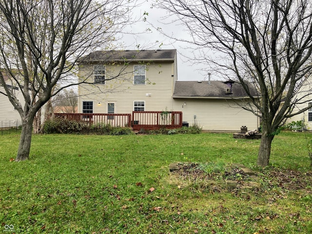 rear view of property featuring a yard and a wooden deck