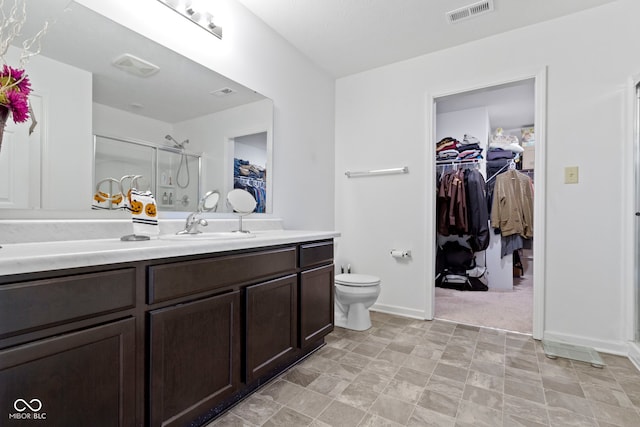 bathroom featuring vanity, toilet, and an enclosed shower