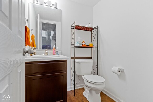 bathroom with vanity, toilet, and wood-type flooring