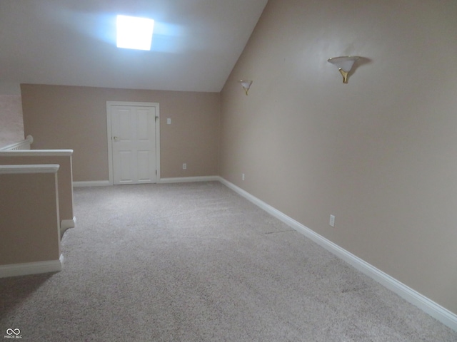 unfurnished room featuring light colored carpet and lofted ceiling