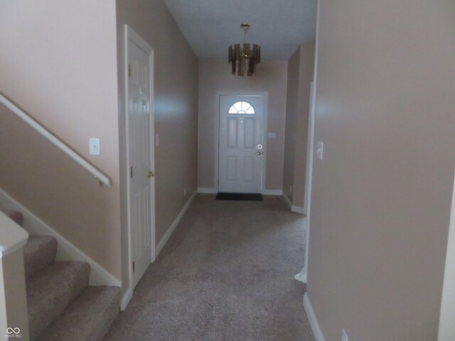 doorway to outside with carpet and an inviting chandelier