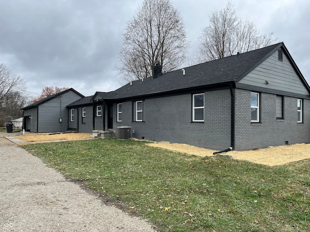 view of front of home with cooling unit and a front yard