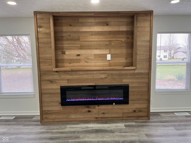 interior details featuring hardwood / wood-style floors, a fireplace, and a textured ceiling