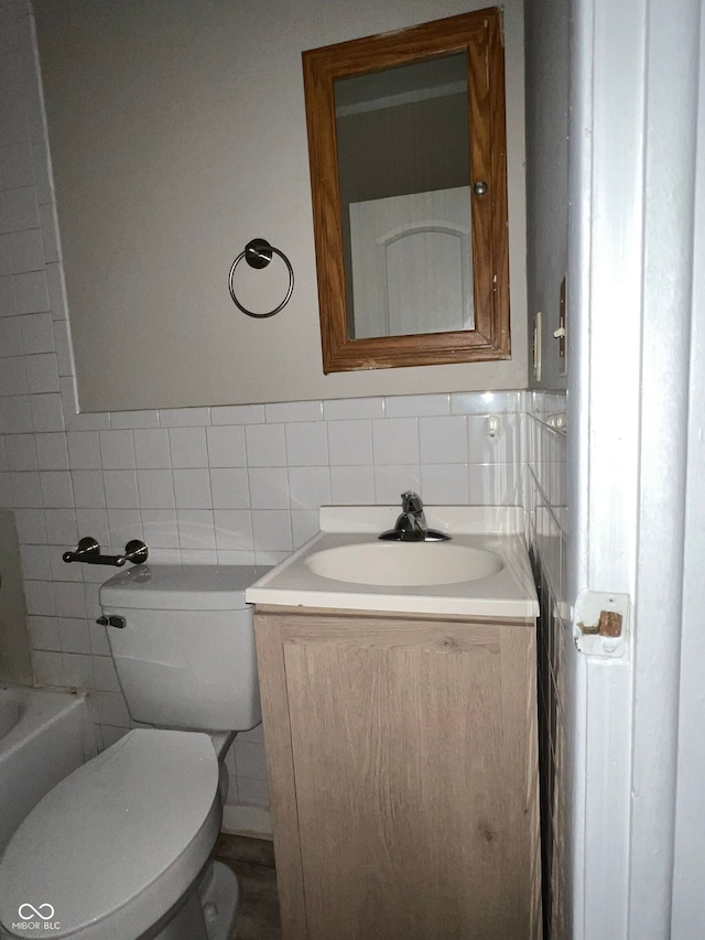 bathroom with vanity, tile walls, and toilet