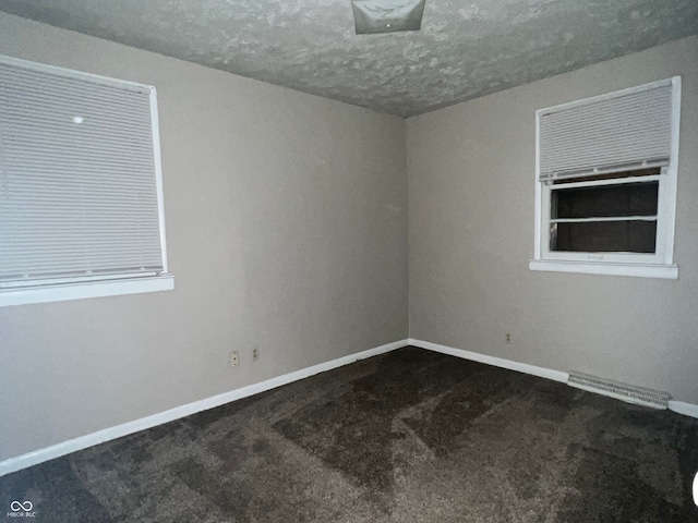 carpeted empty room featuring a textured ceiling