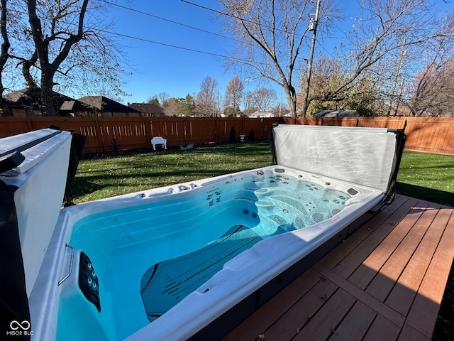 wooden deck with a yard and a covered hot tub