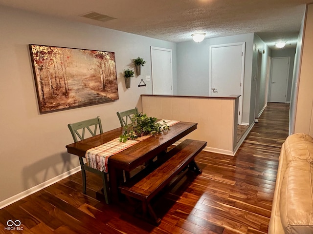 dining space with a textured ceiling and dark wood-type flooring