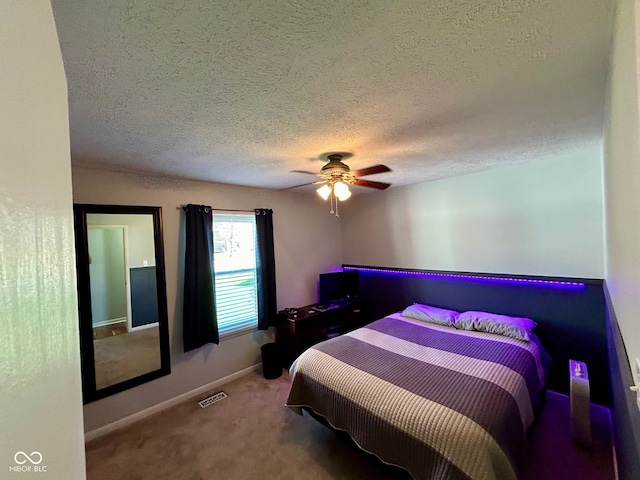carpeted bedroom featuring a textured ceiling and ceiling fan