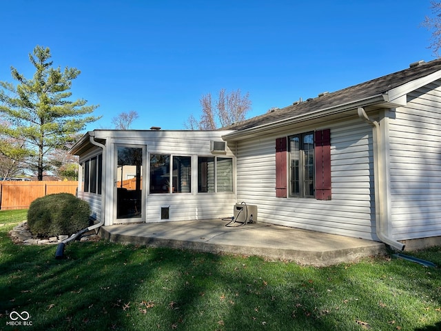 rear view of house featuring a sunroom, a yard, and a patio