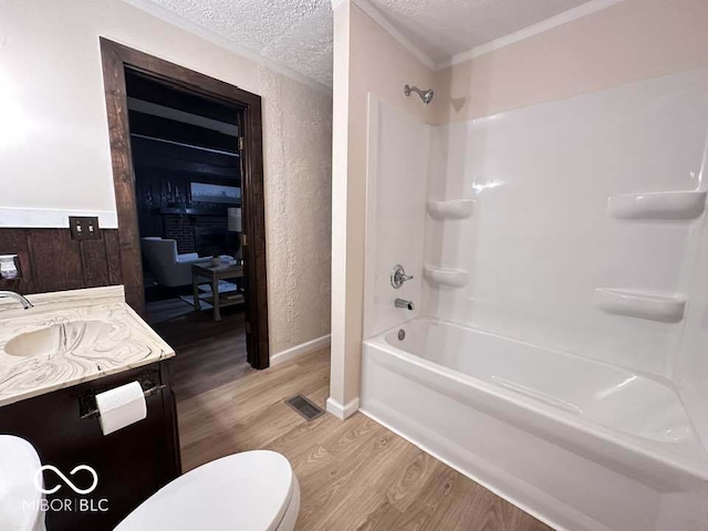 full bathroom featuring shower / bathing tub combination, vanity, toilet, a textured ceiling, and wood-type flooring