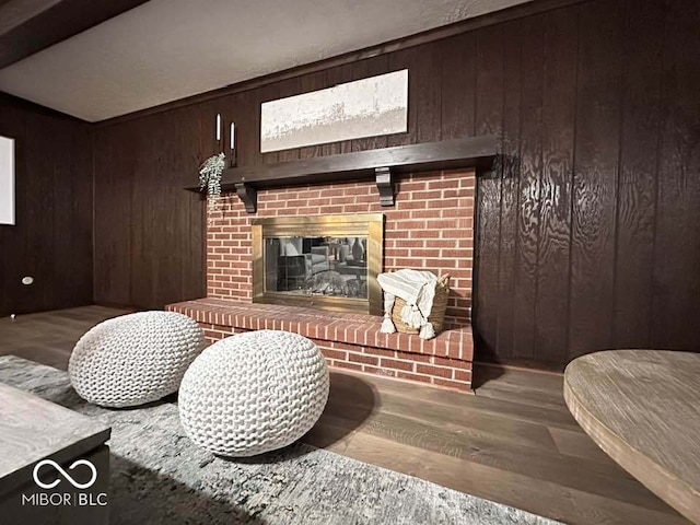 living room featuring hardwood / wood-style floors, wood walls, and a fireplace