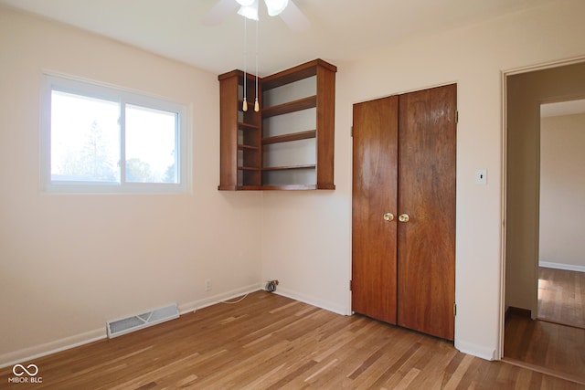 unfurnished bedroom with ceiling fan, a closet, and light wood-type flooring